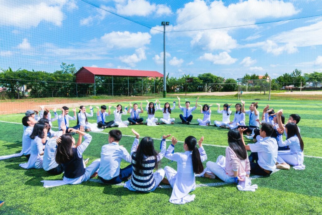 pexels-photo-1164572-1164572 People Sitting on Green Lawn Grass While Doing Hands Up at Daytime